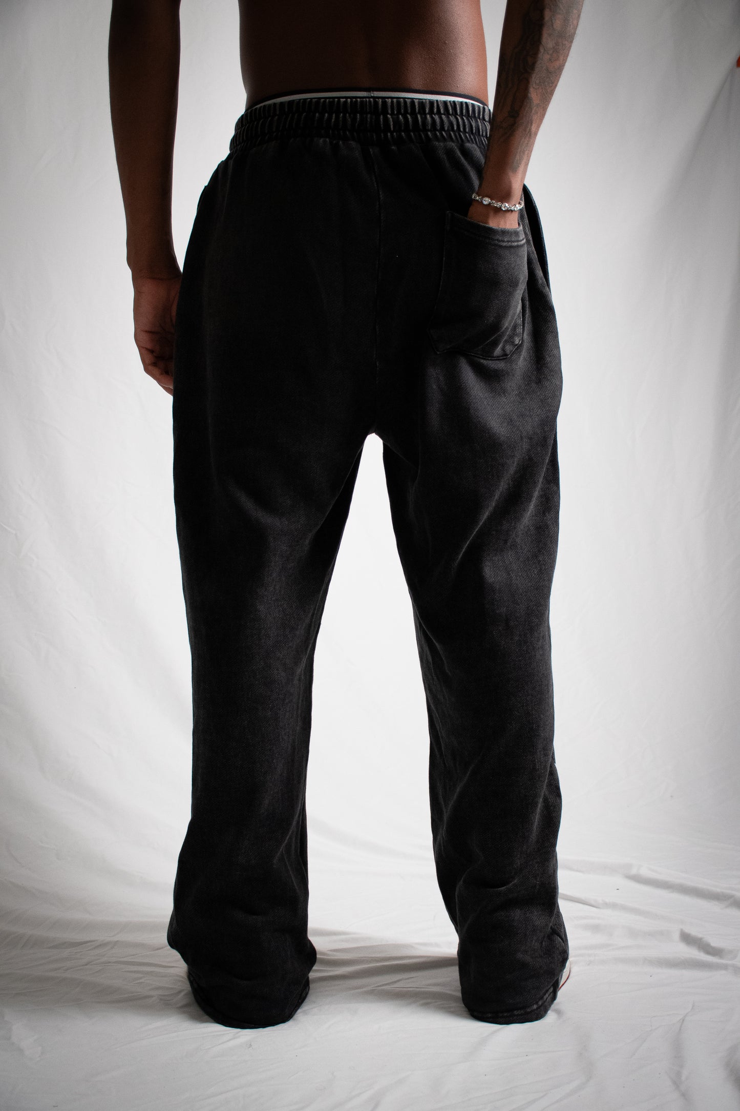 Person wearing black pants on a white background